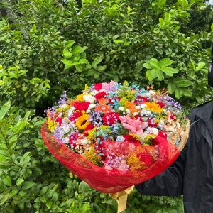 Buquê colorido com rosas vermelhas, girassóis e flores variadas em arranjo premium